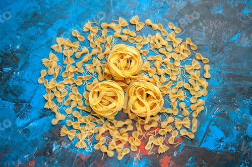 Preview: Dinner preparation with pasta noodles lined up in a row on blue background