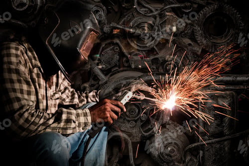 Preview: welder at work with old machine steel background, industry concept