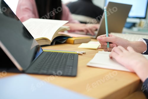 Preview: Young college student using computer and digital tablet studying online.