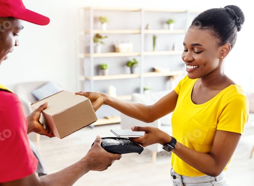 Preview: African Woman Receiving Box From Courier Paying With Smartphone Indoor