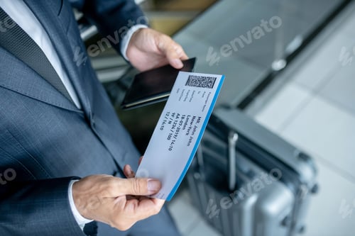Vista previa: Man considering plane ticket at airport