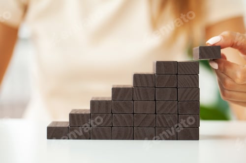 Preview: Women fingers climb up wooden block closeup