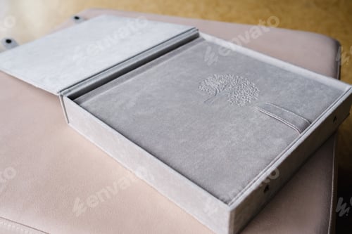 Preview: A photo book in a grey cloth cover lies on the box. the concept of creating books and albums