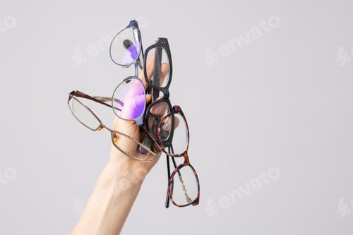 Preview: hand holding many glasses for vision on white background, good vision, selection of glasses