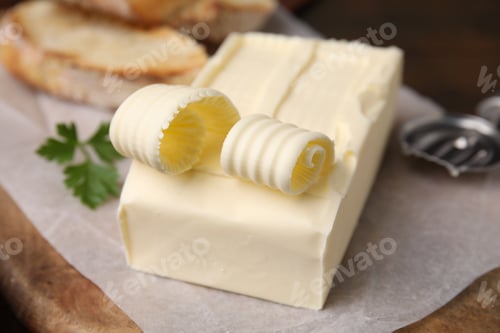Preview: Tasty butter and spoon on wooden board, closeup