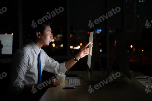 Preview: Young Asian broker international stock traders working at night in office using computer