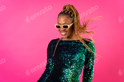 Preview: Black ethnic woman with braids party dancing on pink background, smiling with glasses