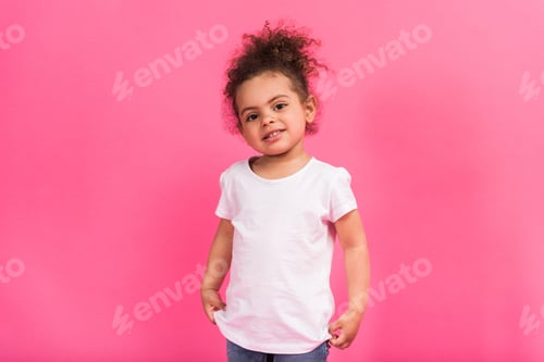 Preview: Smiling happy African american kid in white shirt standing isolated on pink