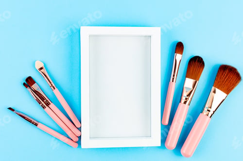 Preview: Various Makeup Brushes pink set with place for text on blue paper Background,