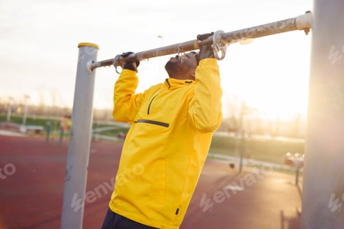 Preview: Man working out in an outdoor gym doing pull-ups