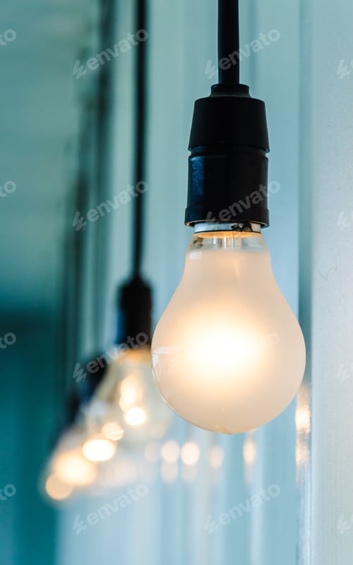 Preview: Illuminated Light Bulbs Hanging Against a Wall
