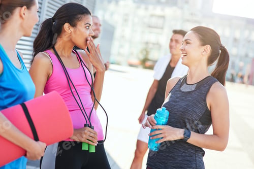 Preview: Smiling girls talking on street after fitness