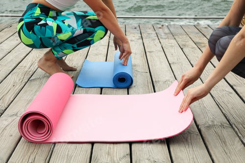 Preview: Women Preparing Yoga Mats on Dock by Water