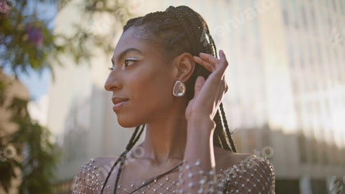 Preview: African woman touching braids looking camera posing sunbeams square portrait