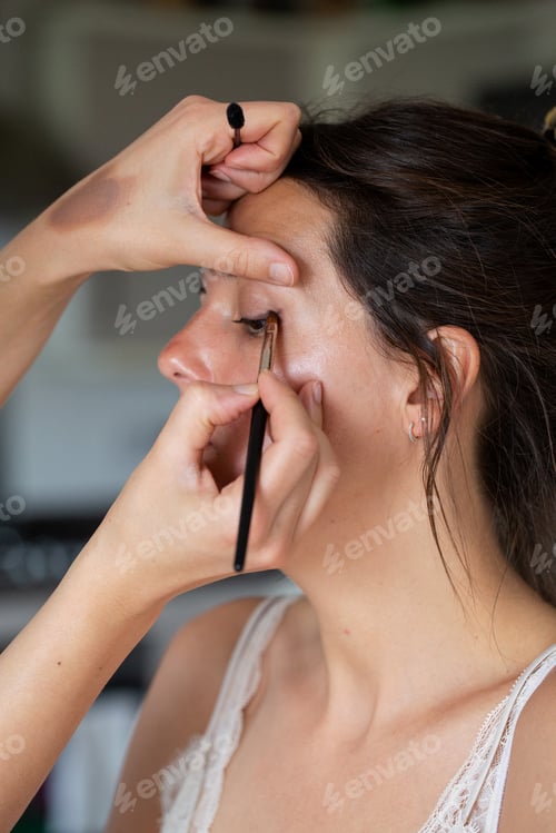 Preview: A professional make up artist at work, creating a look for a young woman.