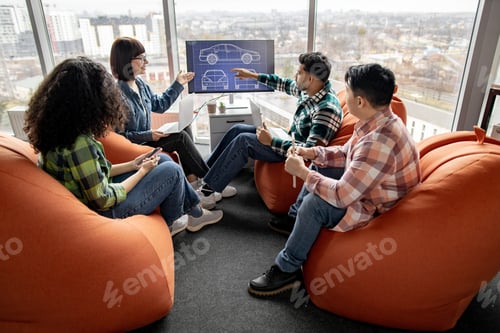 Preview: Coworkers examining car model on display in open office