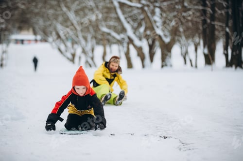 Preview: Mother and son sledding in winter park