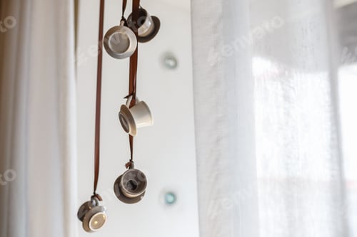 Preview: tiny coffee cups hung on a cafe window
