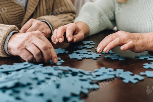 Preview: cropped view of retired couple playing with puzzles at home