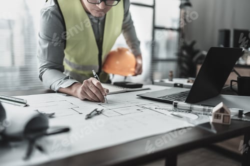 Preview: Engineering hold safety helmet working with drawings inspection on the office desk.