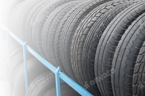 Preview: Rack with variety of car tires in automobile store. Many black tires. Tire stack background