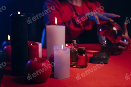 Preview: selective focus of blurred candles near cropped fortune teller and crystal ball isolated on black