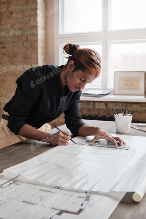 Preview: Engineer with ponytail drawing house plan in office