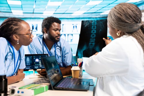 Preview: Group of doctor and junior nurses specialists in scrubs analyzing results