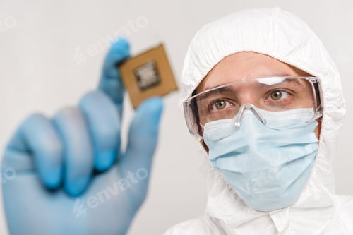 Preview: selective focus of scientist looking at microchip in latex glove isolated on grey