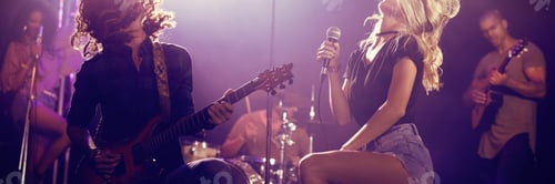 Preview: Singer and male guitarist with tousled hair performing at nightclub