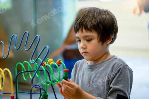 Preview: boy playing in kid club with vintage tone, Child having fun playing colorful toys in kid playroom.