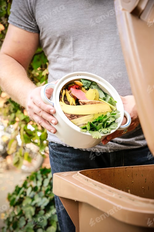 Preview: Mature man throwing kitchen scraps into bio-waste container