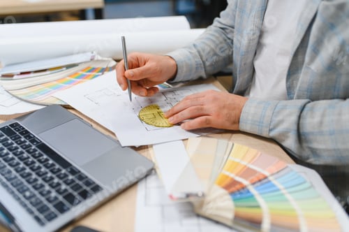 Preview: Interior designer working on architectural blueprint with color palette