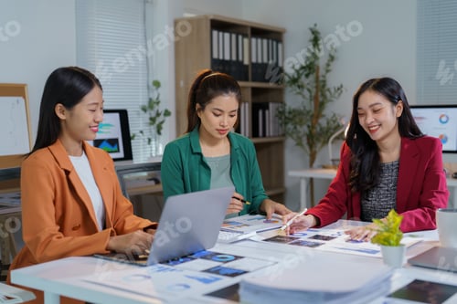 Preview: Three asian businesswomen are working together in the office, analyzing financial reports, using a l