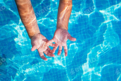 Preview: Baby hands in the water of a pool with palms up in the sun.