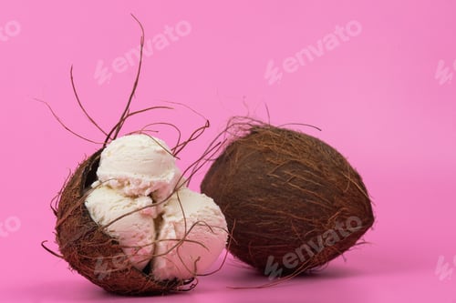 Preview: Vanilla ice cream balls in an empty coconut decorated with mint leaves on a pink background