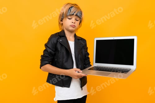 Preview: Stylish young boy in black jacket and white t-shirt shows his laptop