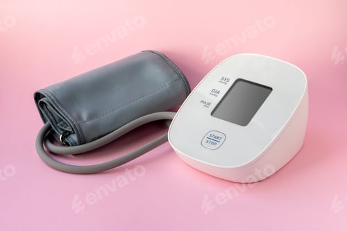 Preview: Automatic blood pressure monitor on pink background. Medical electronic tonometer
