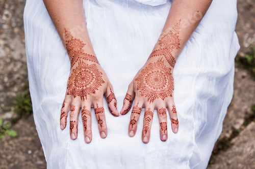 Preview: Woman in white dress with henna tattoo on hands