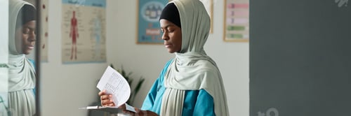 Preview: African Muslim Woman Reading Paper in Medical Office Setting