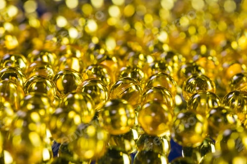 Preview: yellow medical capsules on a mirror surface