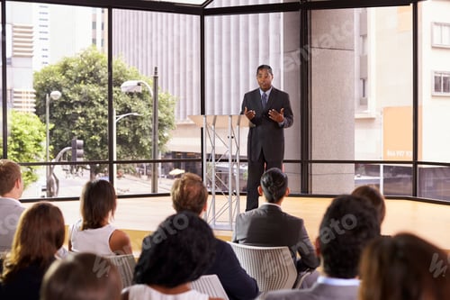 Preview: Black businessman presenting seminar gesturing to audience