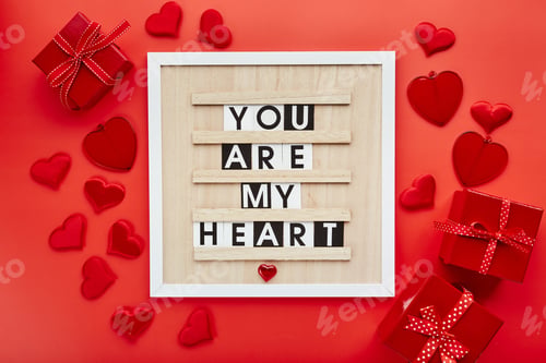 Preview: Letter board with hearts and gift boxes on red background. Top view. Background for Valentine's