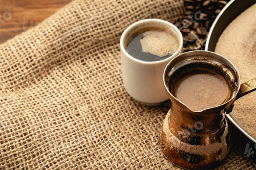 Preview: White coffee cup with roasted beans on sackcloth