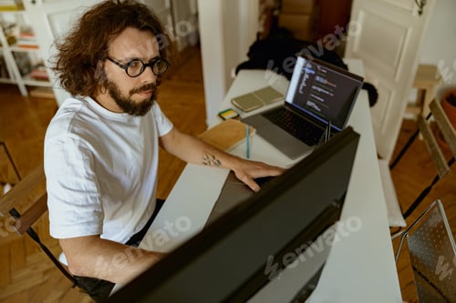 Preview: Young businessman using computer working remotely from modern home office. Distance work concept