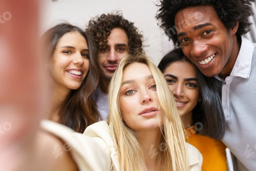 Preview: Multi-ethnic group of friends taking a selfie together while having fun outdoors