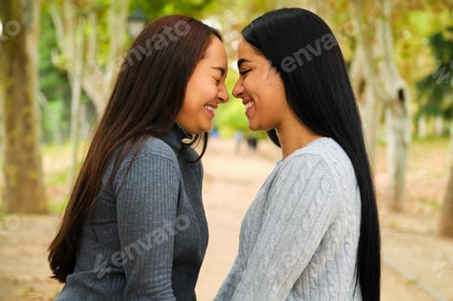 Preview: Happy Latin lesbian couple laughing in a park.