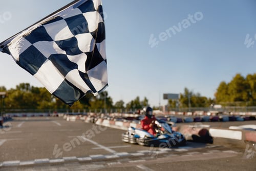 Preview: Go-kart driver crossing at finish line moving to checkered racing flag