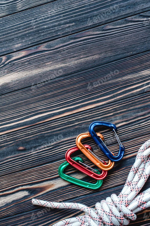 Preview: Nice polished. Isolated photo of climbing equipment. Part of carabiner lying on the wooden table