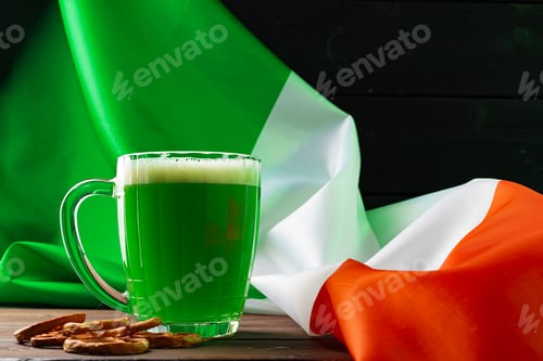 Preview: Glass of green beer against flag of Ireland